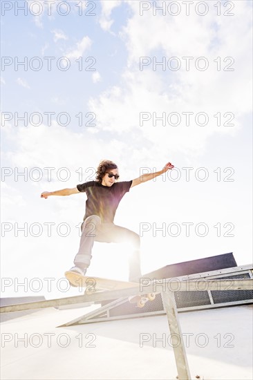 Man jumping on skateboard in skatepark