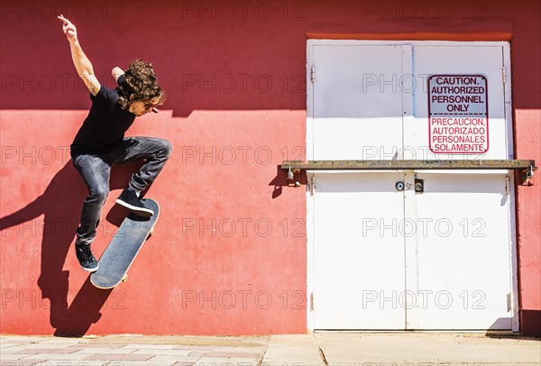 Man skating near red wall