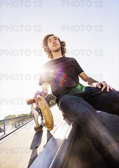 Skateboarder resting in skatepark