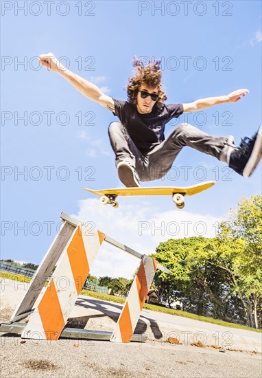 Man jumping on skate board in construction site