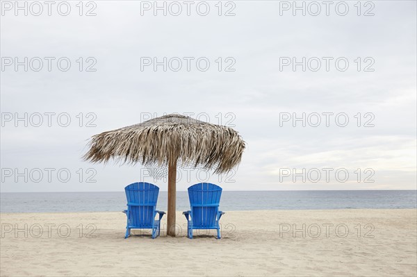 View of deckchairs on beach