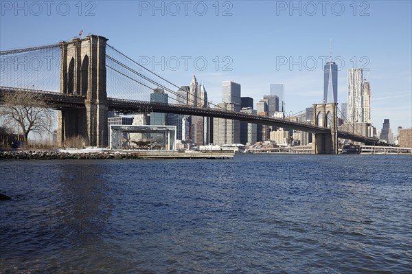 View of waterfront cityscape with suspension bridge