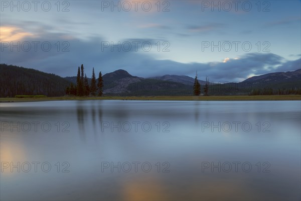 Scenic view of lake and hills at dawn