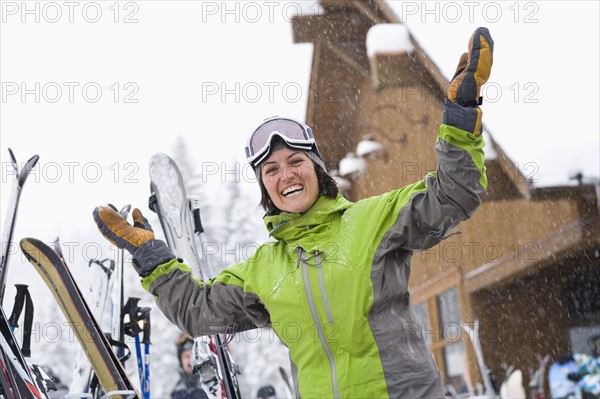 Woman wearing ski googles with hands raised