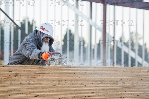 Man cutting wooden planks