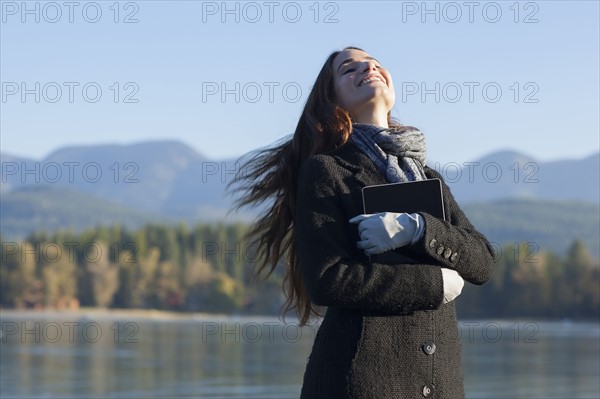 Woman with tablet by lake