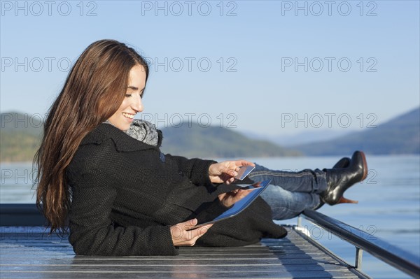 Woman with tablet by lake