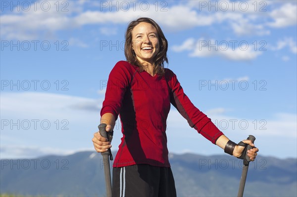 Portrait of smiling woman with trekking poles