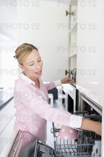 Woman putting dishes in dishwasher