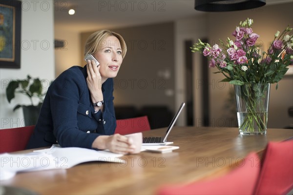 Woman talking on phone and making notes