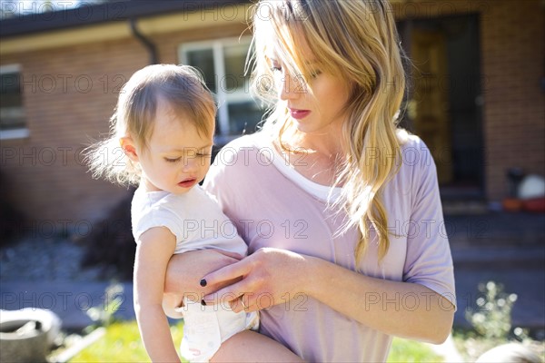 Mother and daughter (12-17 months) in backyard