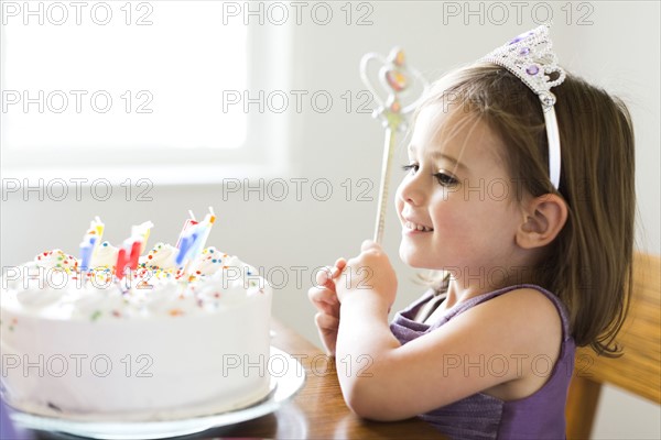 Girl (4-5) looking at birthday cake