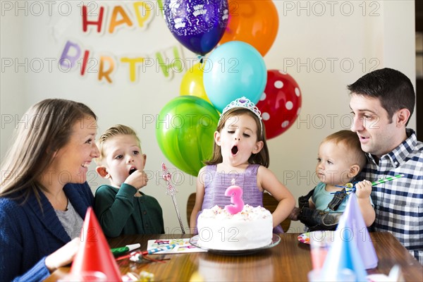 Family with three children (2-3, 4-5) celebrating birthday