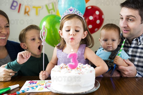 Family with three children (2-3, 4-5) celebrating birthday