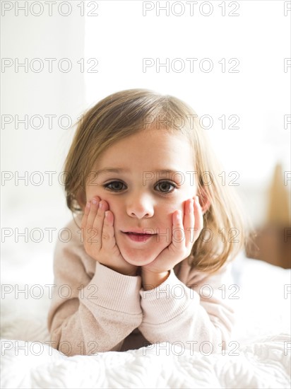 Portrait of girl (4-5) lying on bed