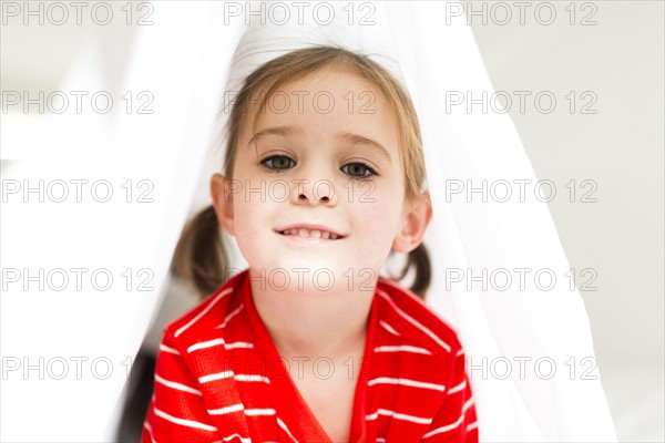 Girl (4-5) hiding in bed