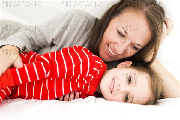 Mom and daughter (2-3) lying in bed