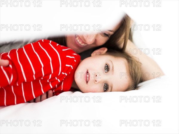 Mom and daughter (2-3) lying in bed