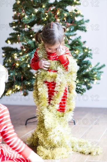 Girl (4-5) decorating christmas tree