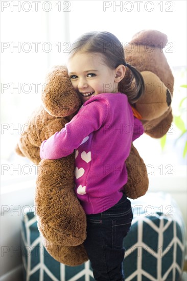 Portrait of girl (4-5) hugging teddy bear