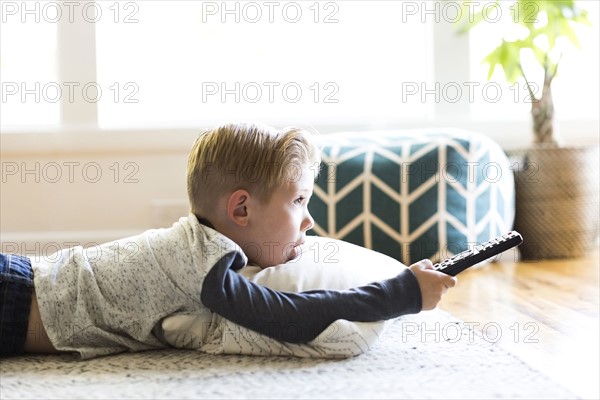 Boy (4-5) watching tv in living room