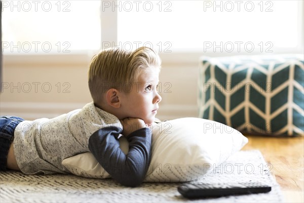 Boy (4-5) watching tv in living room