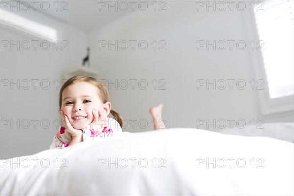 Girl (2-3) lying on bed