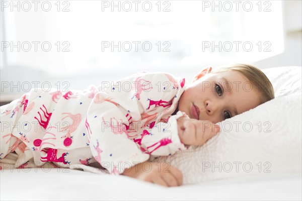 Girl (2-3) lying on bed