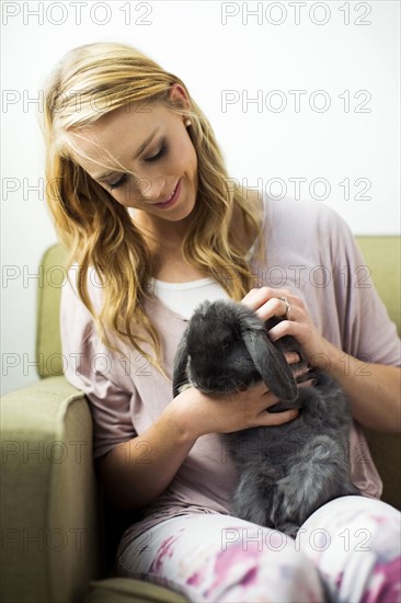 Young woman stroking rabbit