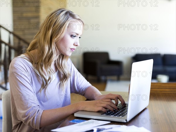 Young woman using laptop at table