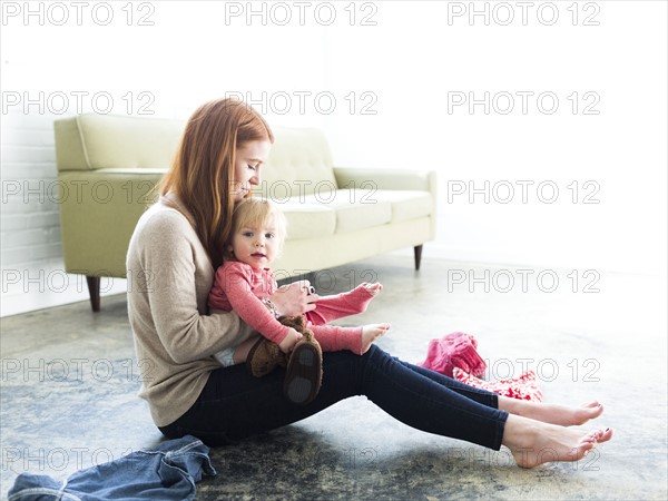 Mother dressing son (2-3) in living room