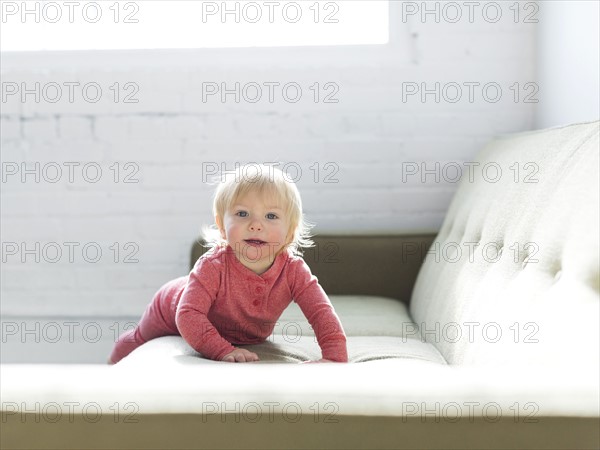 Baby boy (2-3) crawling on sofa