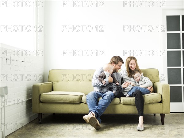 Family embracing on sofa