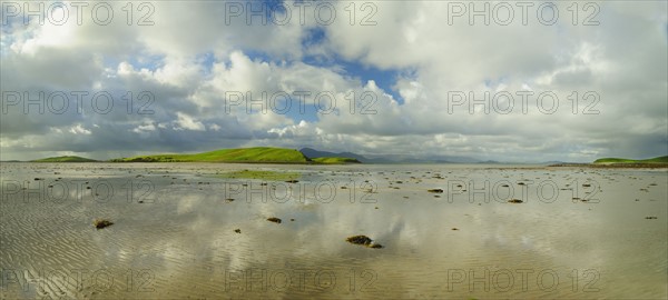 Panoramic landscape with water, clouds and hill on horizon