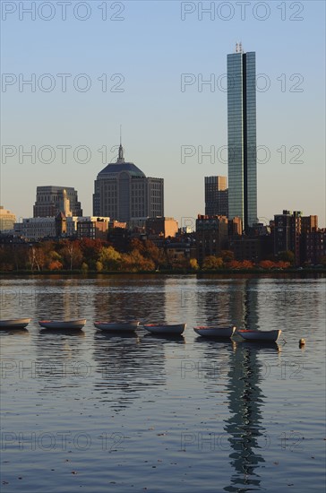 Row of boats on river, waterfront in background