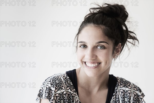 Portrait of teenage girl (14-15) smiling in studio.