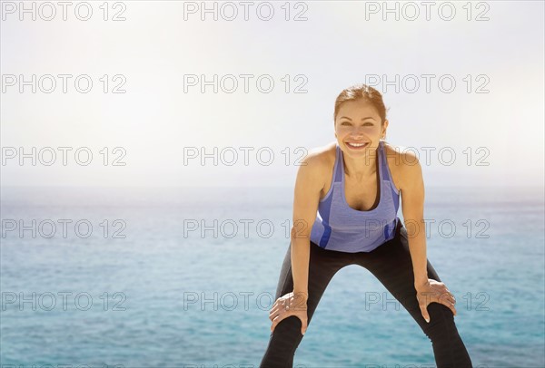 Young woman exercising by sea.