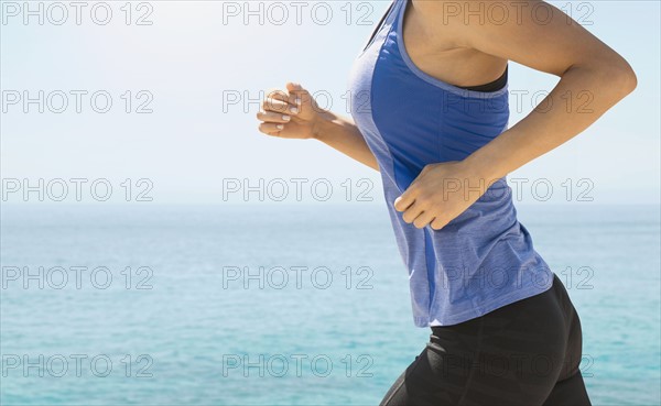 Young woman exercising by sea.