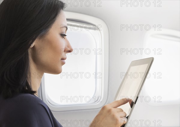 Young woman using tablet on plane.