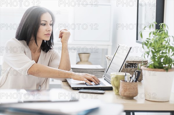 Woman sitting at desk with laptop.