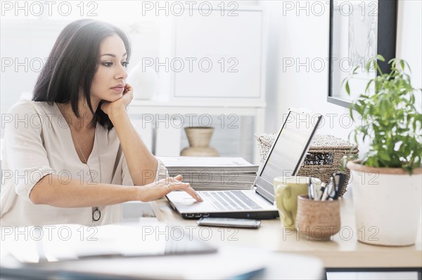 Woman sitting at desk with laptop.