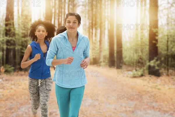 Portrait of teenage girls (14-15, 16-17) running.