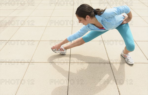 Teenage girl (14-15) stretching.