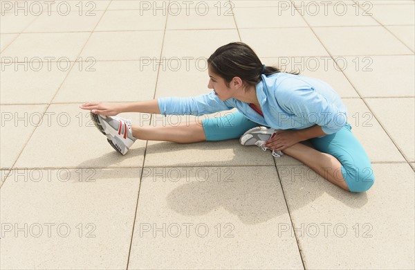 Teenage girl (14-15) stretching.