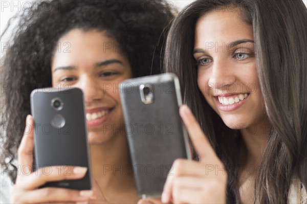 Teenage girls (14-15, 16-17) using smart phones.