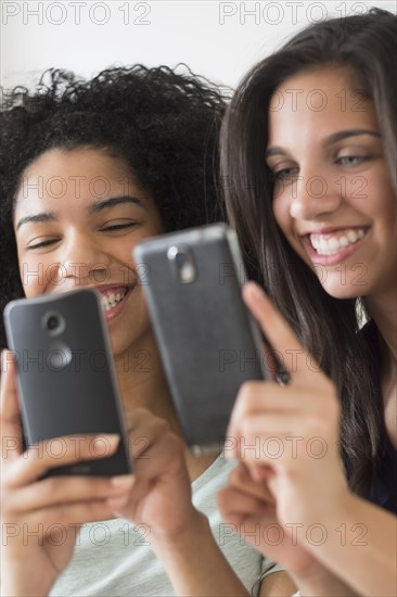 Teenage girls (14-15, 16-17) using smart phones.