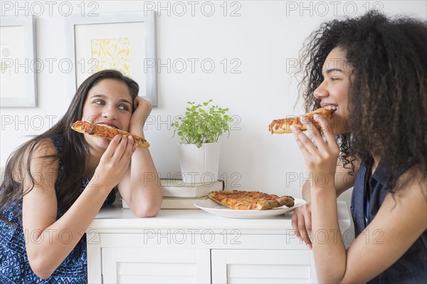 Teenage girls (14-15, 16-17) eating pizza.