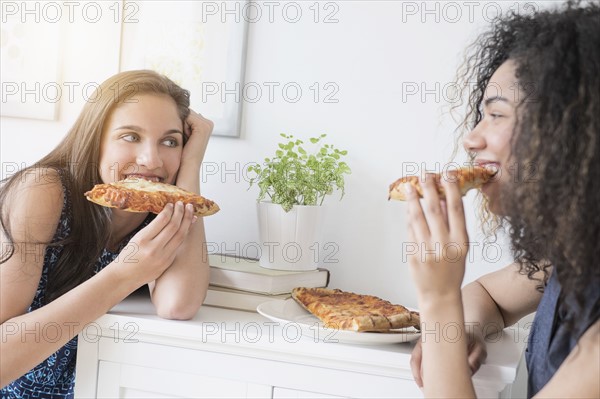 Teenage girls (14-15, 16-17) eating pizza.