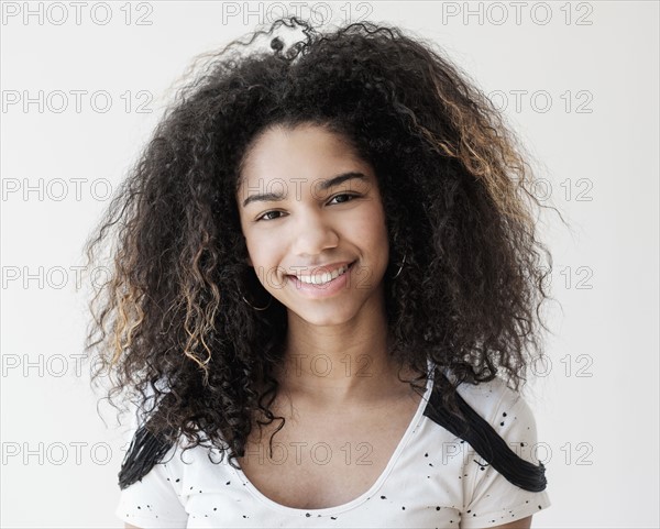 Portrait of teenage girl (16-17) on white background.