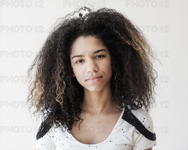 Portrait of teenage girl (16-17) on white background.